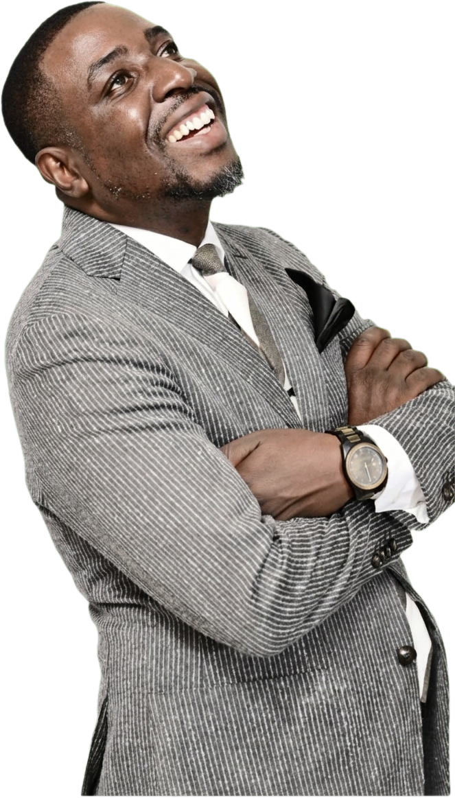 Elisha Shamu smiling in a pinstripe suit, arms crossed